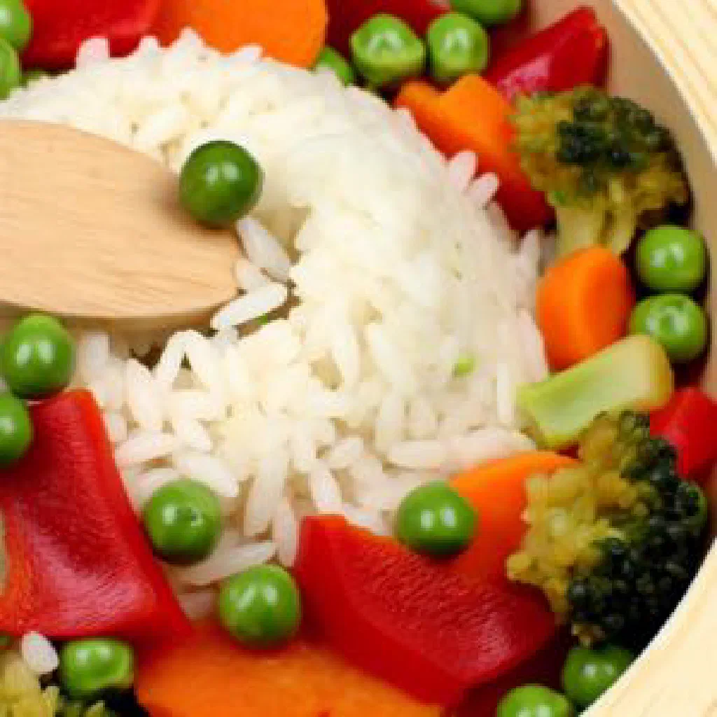 A bowl of Albanian Të Dytë rice with vegetables and fresh herbs