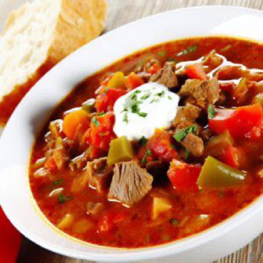Makhmud with tender braised meat, peppers and tomatoes, garnished with fresh herbs
