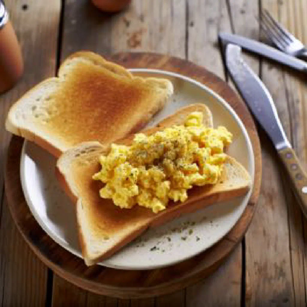 Spiced scrambled eggs served over toasted bread with fresh coriander