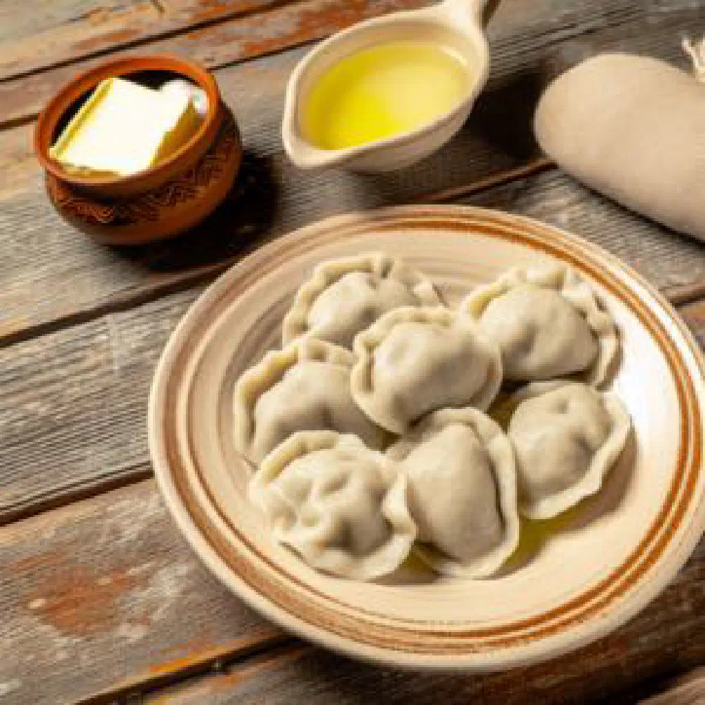 Golden pan-fried kletski dumplings garnished with fresh herbs and soured cream