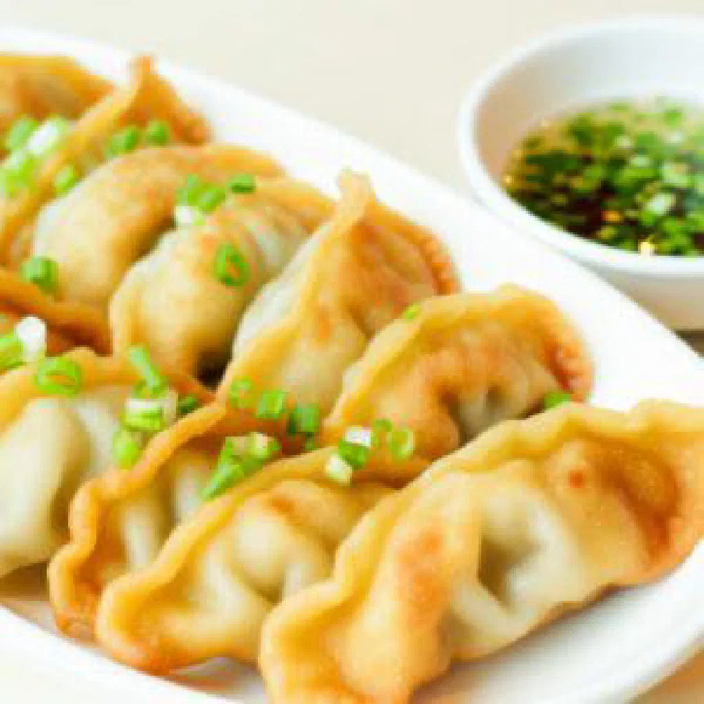 Golden-fried Belarusian mandele dumplings garnished with fresh dill