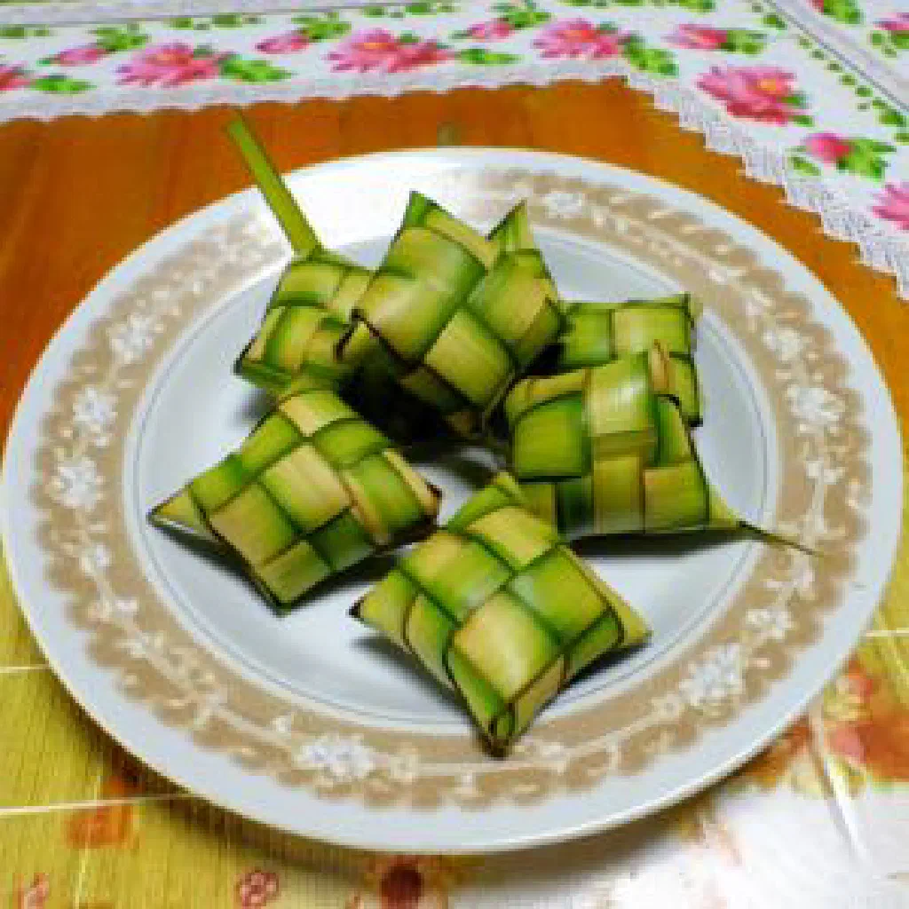 Woven leaf pouches of compressed steamed rice ketupat on a platter