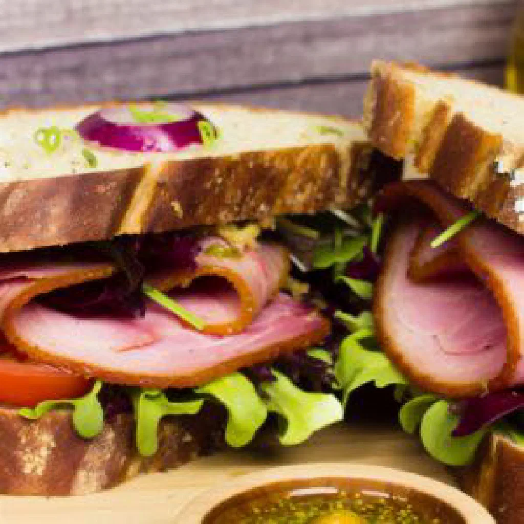 Peameal bacon sandwich with golden pork slices in a soft bun