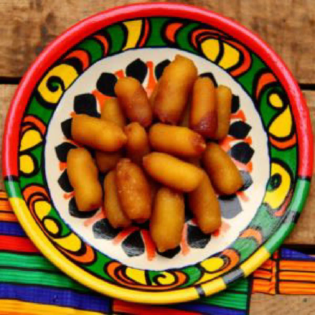 Golden fried Asabe Zainab pastry rolls soaked in syrup and topped with ground pistachios