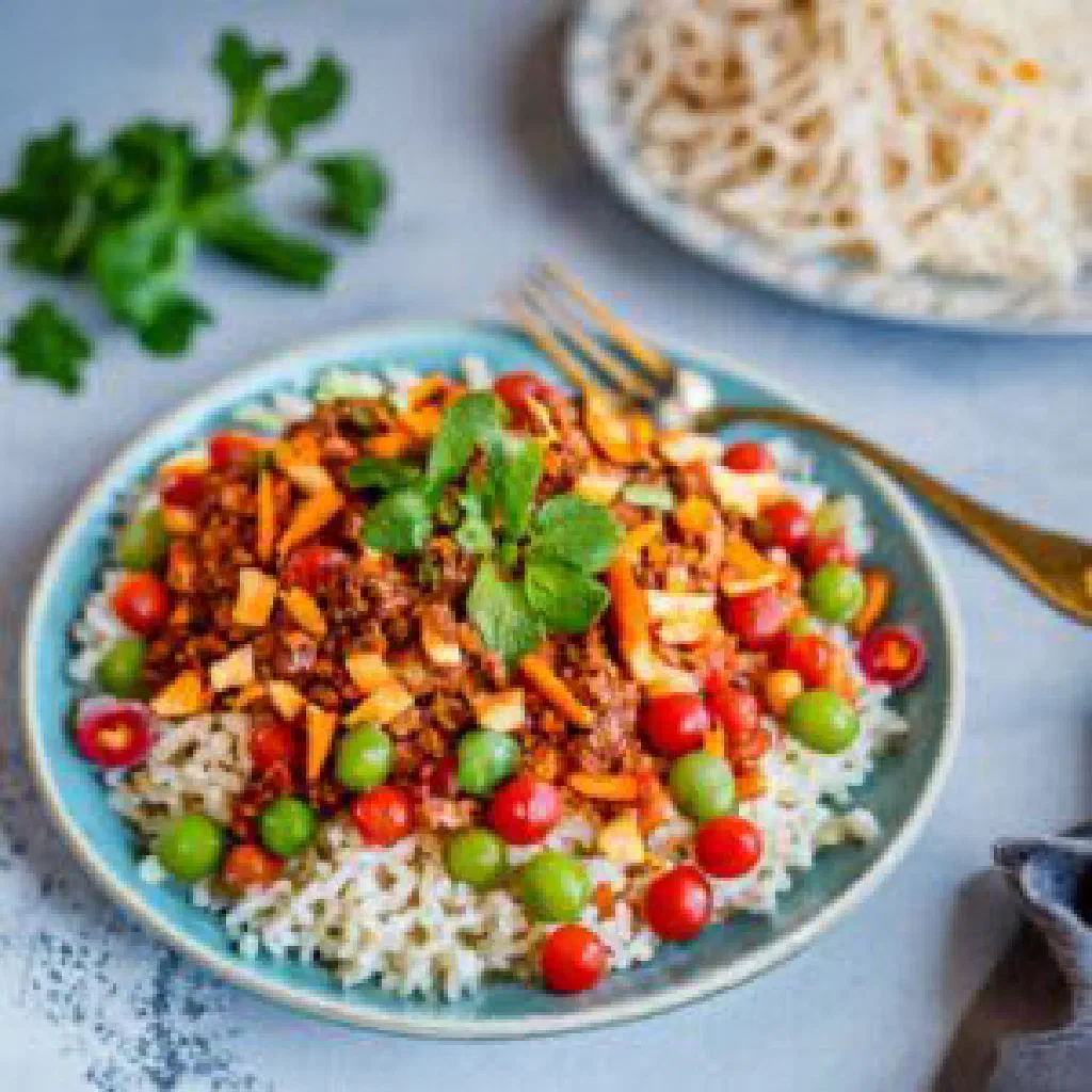 A bowl of Egyptian koshari with rice, lentils, pasta and tomato sauce