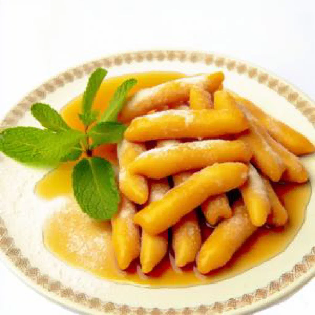 Golden fried Zeinab fingers dusted with cinnamon on a plate