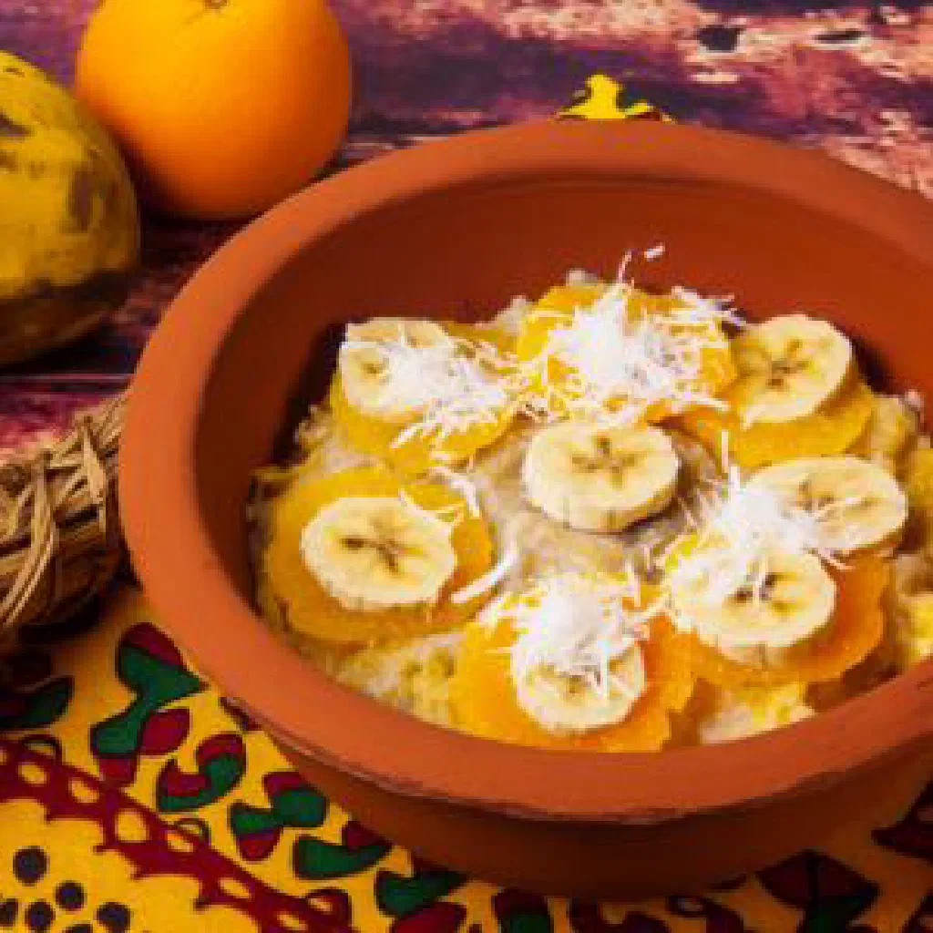 Akwadu with sliced plantains, meat and peppers in a colourful bowl