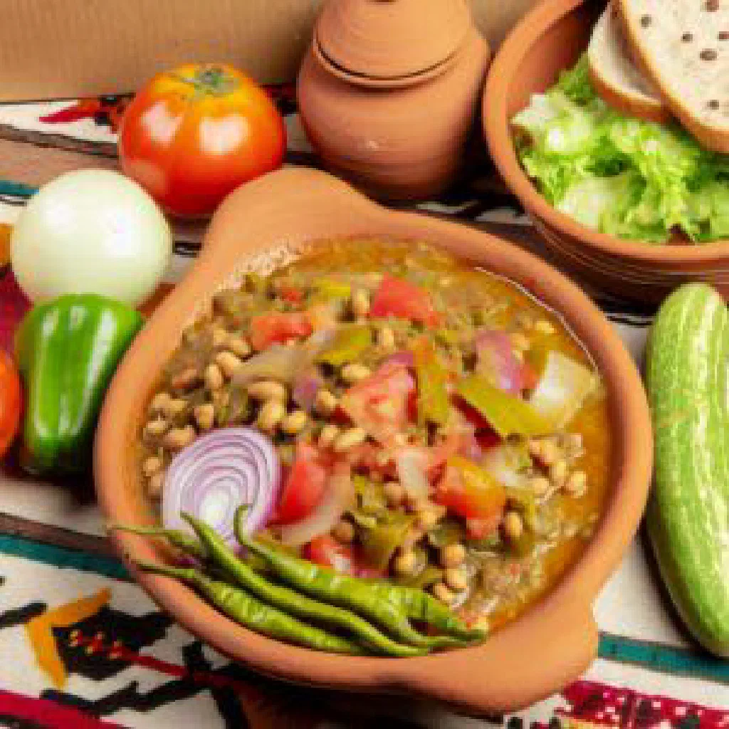 A bowl of foul with fava beans, fresh herbs and a drizzle of olive oil