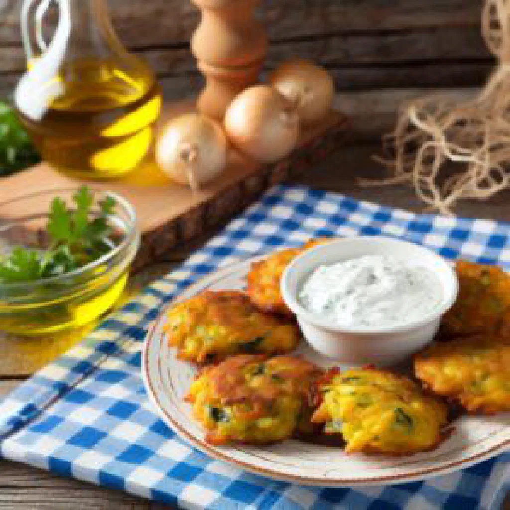 Golden Greek courgette and feta fritters served with a yoghurt dip and lemon