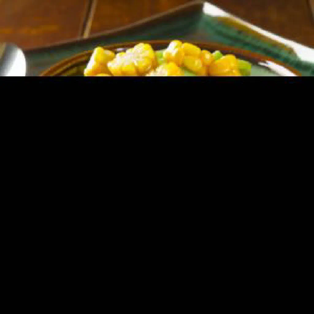 A bowl of Haitian corn and beans garnished with fresh herbs