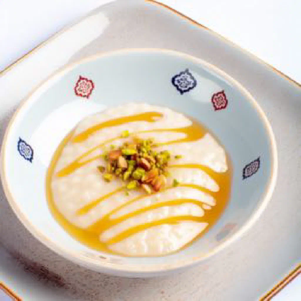 A bowl of creamy Lebanese ashta topped with honey and chopped nuts