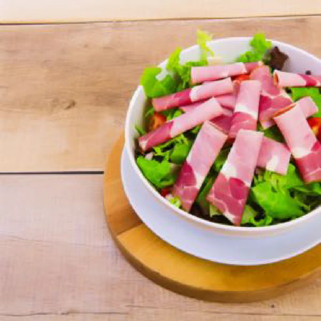 Luxembourgish egg salad with diced ham and spring onions in a bowl