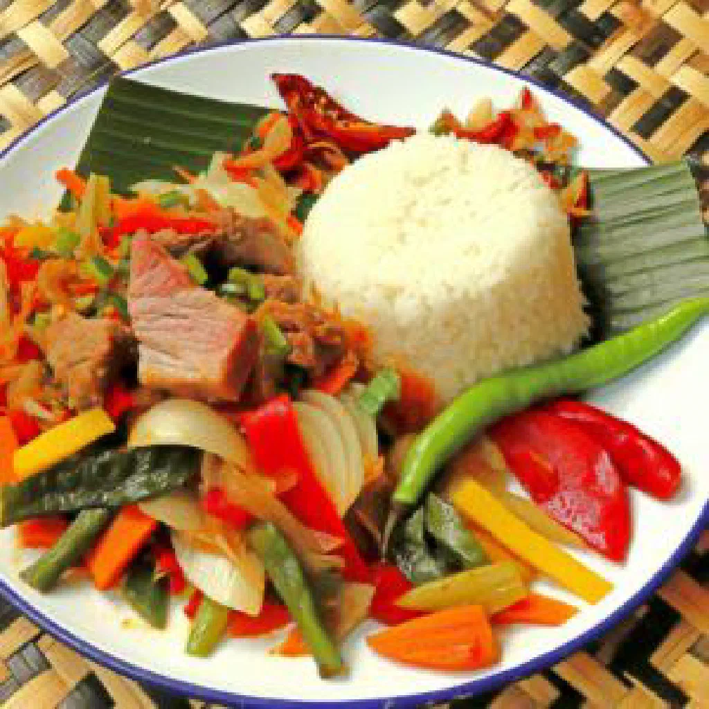 Tender pork simmered in a fiery Malagasy chilli sauce, garnished with fresh herbs