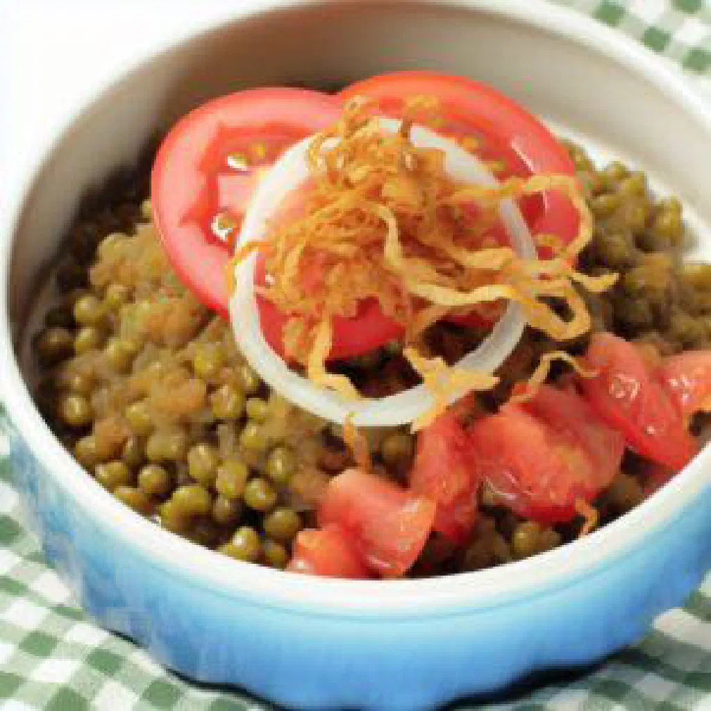 Bowl of Mzuzu Mbewe mung bean stew garnished with fresh herbs
