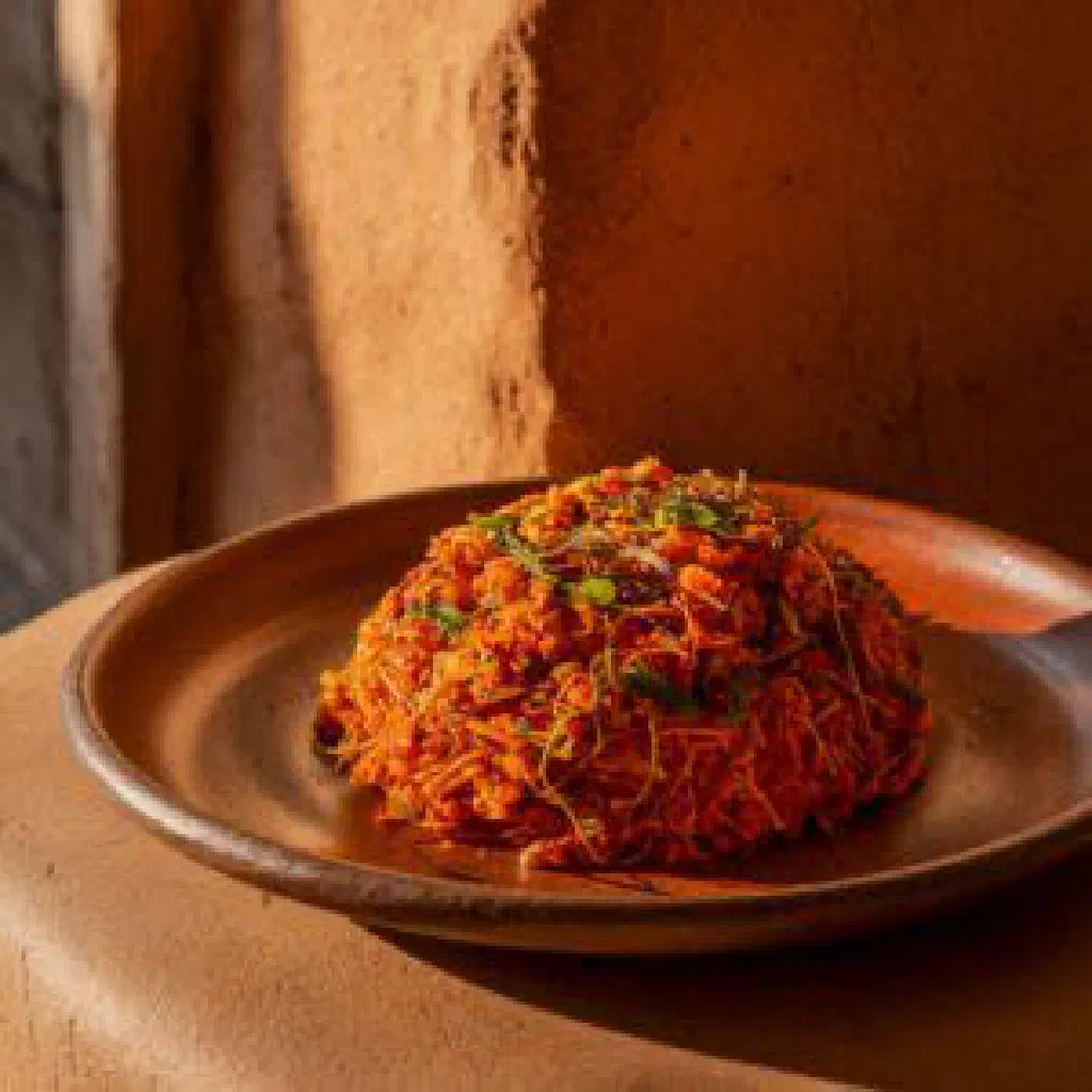Smooth cassava flour porridge served in a bowl with a vegetable sauce