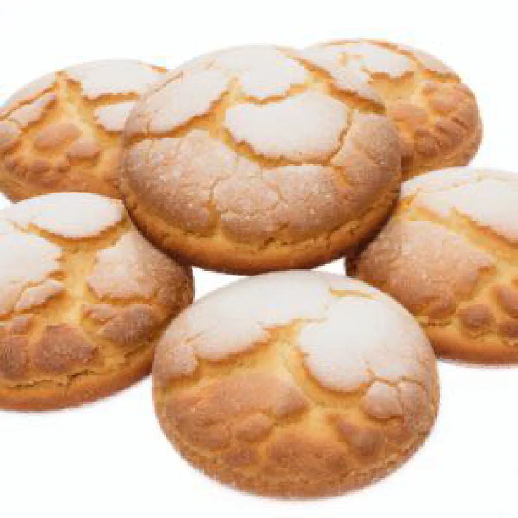 Golden Maltese almond biscuits dusted with icing sugar on a plate