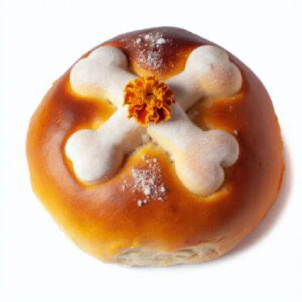 Round sugar-dusted pan de muerto with decorative bone-shaped strips on top