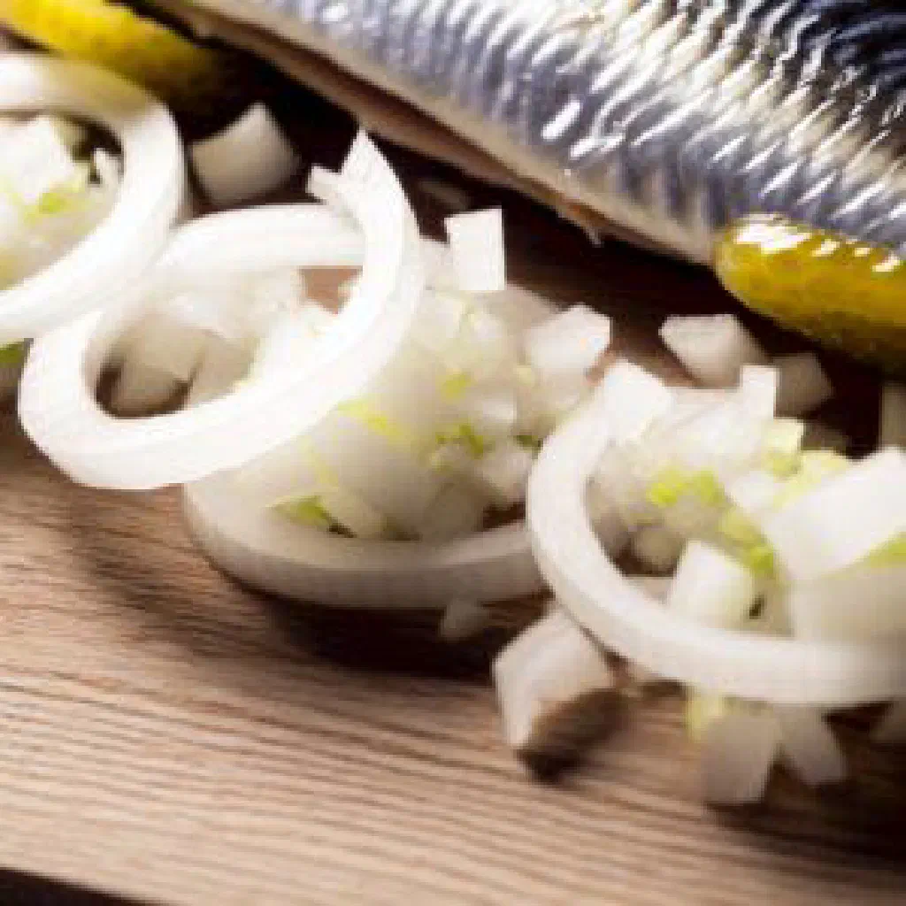 Hollandse Nieuwe raw herring fillets topped with chopped onions and gherkins