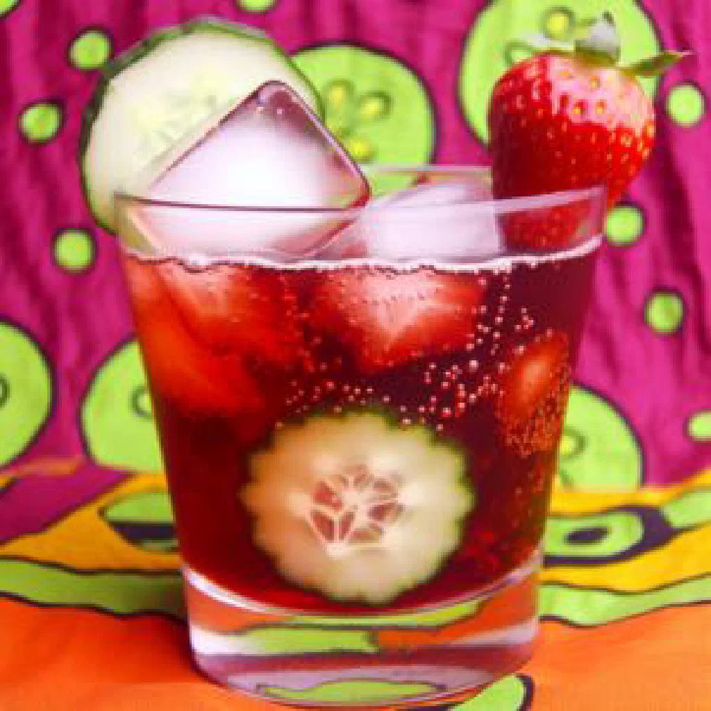A tall glass of Chapman drink with ice and fresh fruit slices