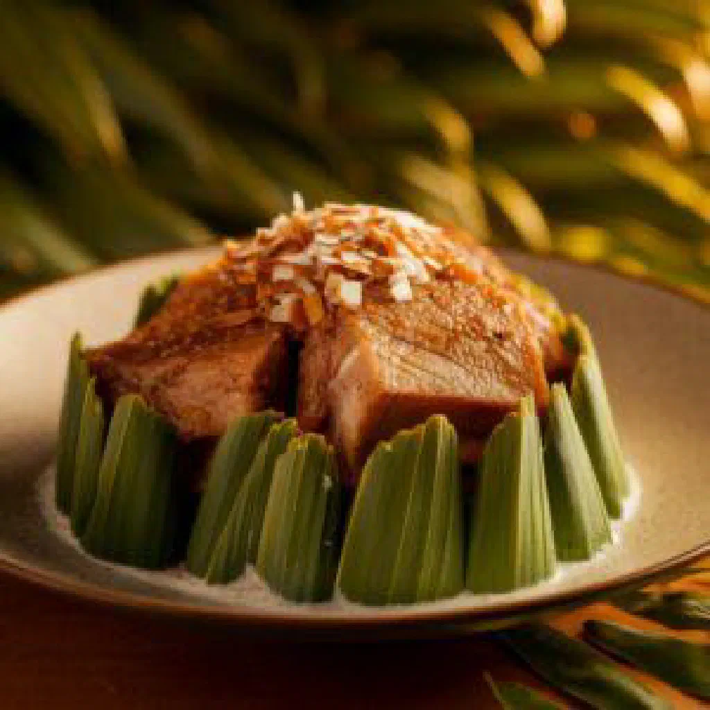 Koni fish simmered in coconut milk, garnished with fresh coriander and lime