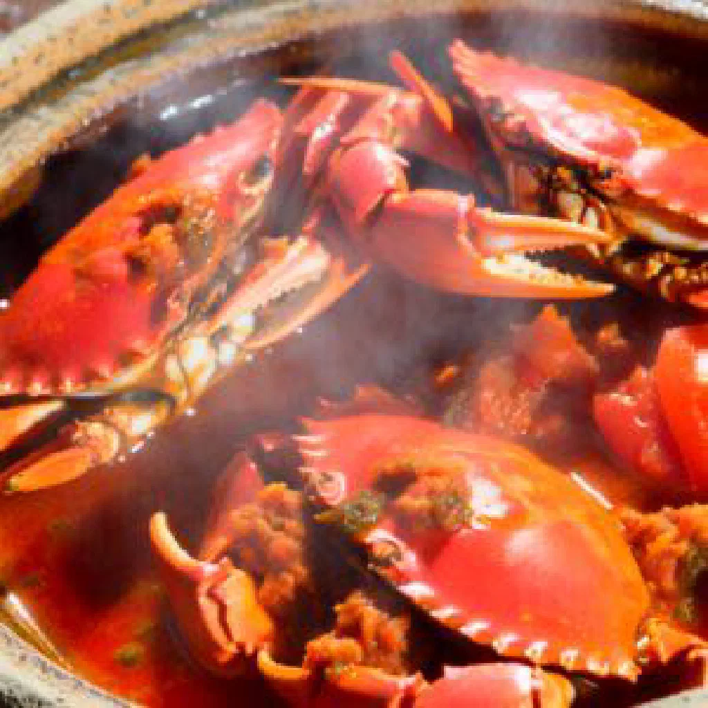 Spicy crab pieces in a rich chilli and turmeric sauce with fresh coriander