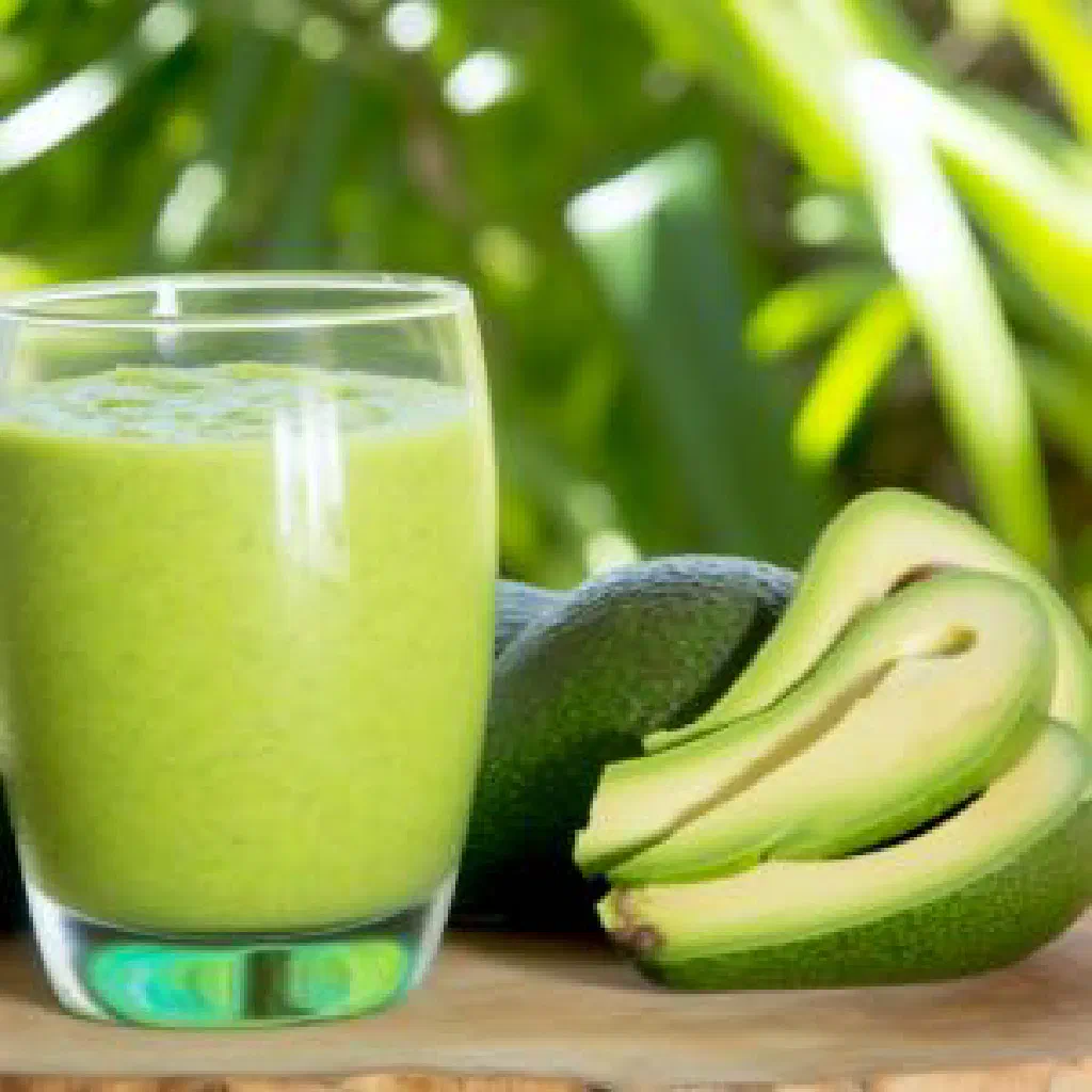 Creamy avocado punch in a tall glass with lime and mint