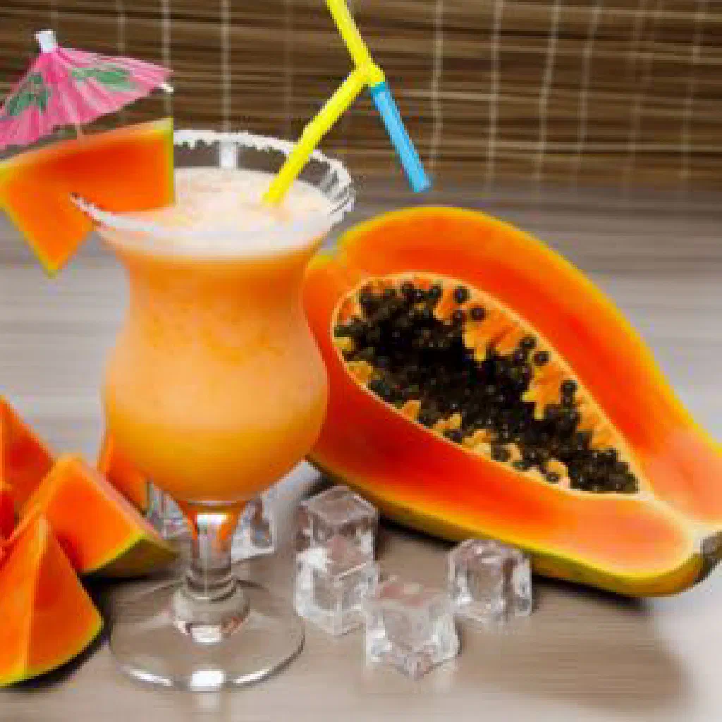 Chilled papaya punch in a tall glass with mint and a slice of lime