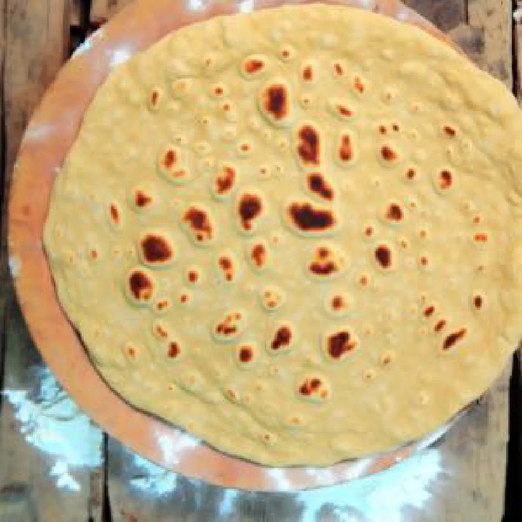 Stack of soft Sudanese gurrasa flatbreads served with stew