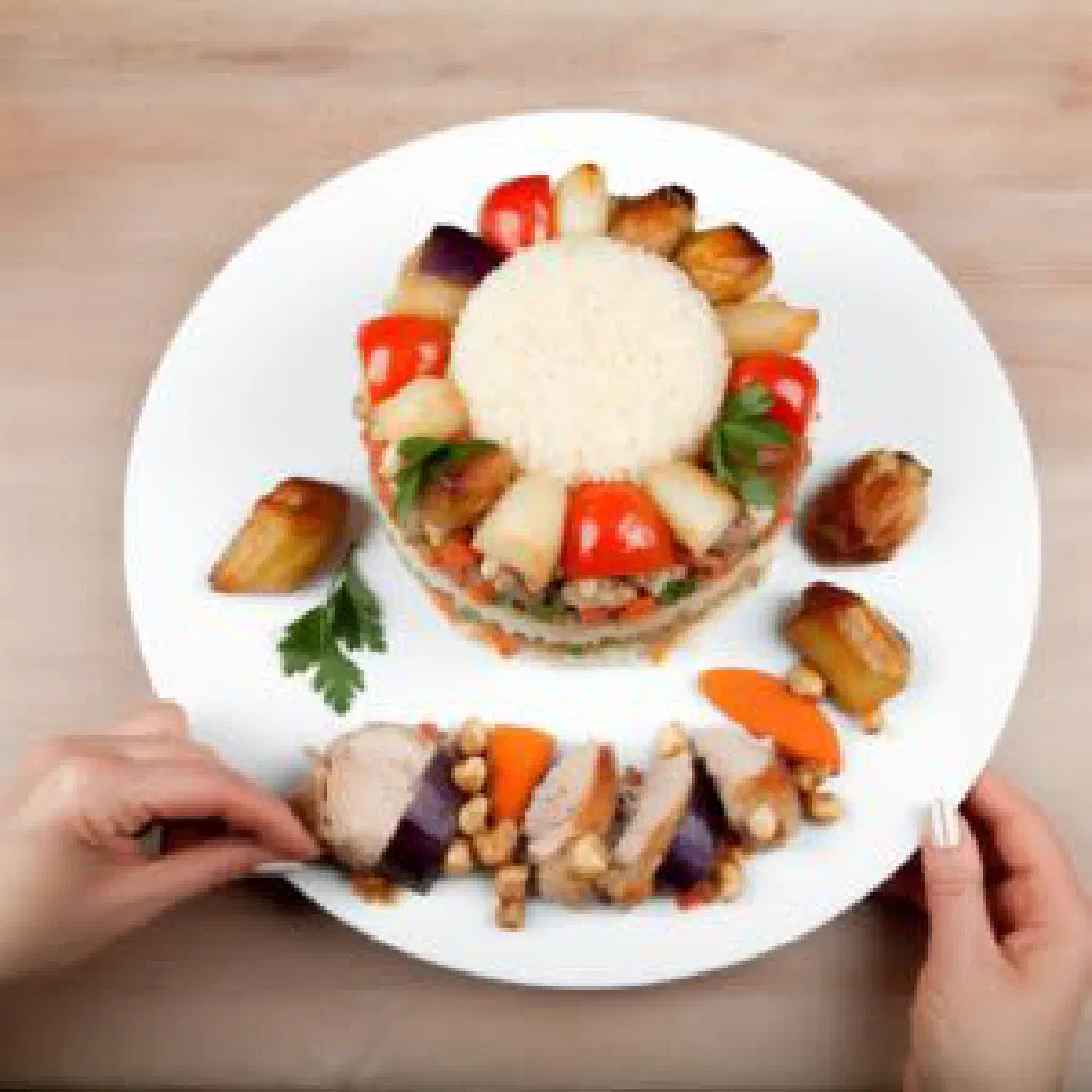 Upside-down maqluba rice cake layered with meat and vegetables, garnished with fresh herbs