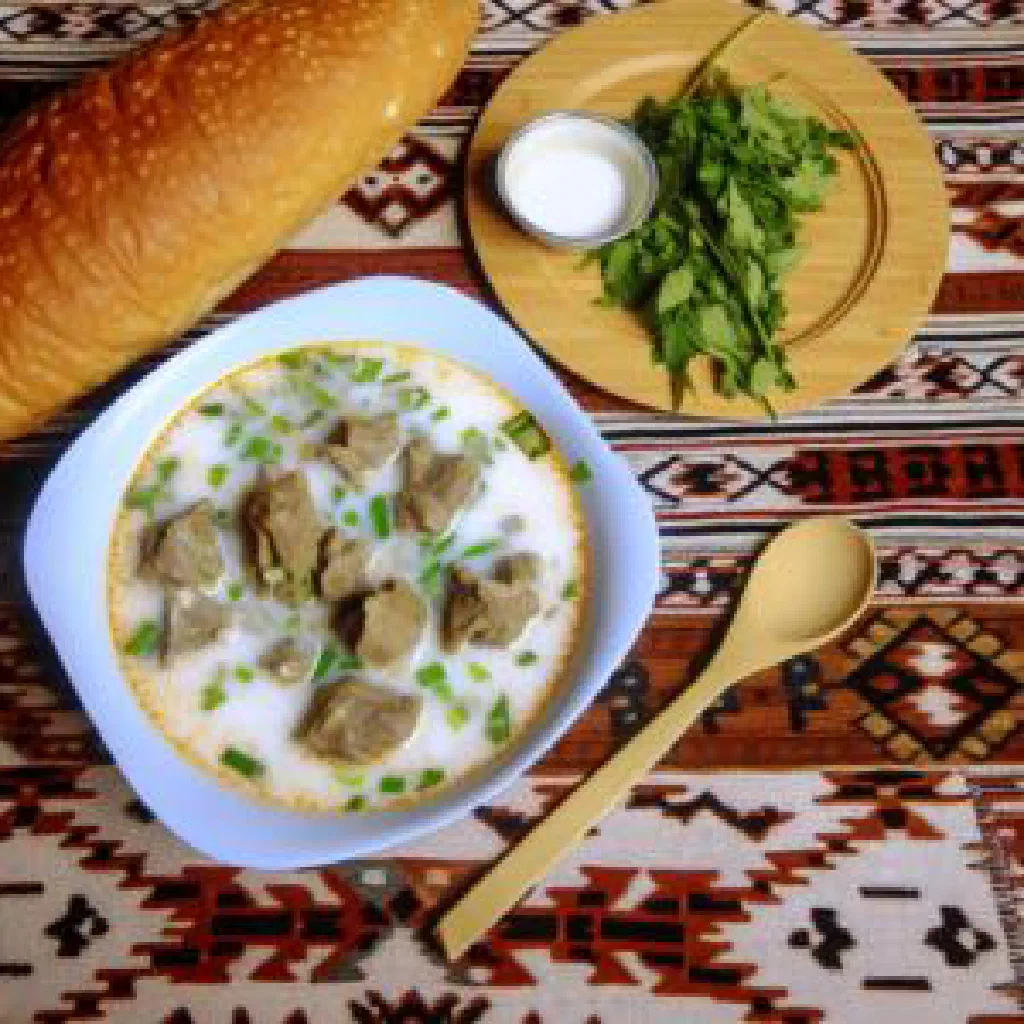 Golden pan-fried Gandush dough parcels with a herb garnish and yoghurt