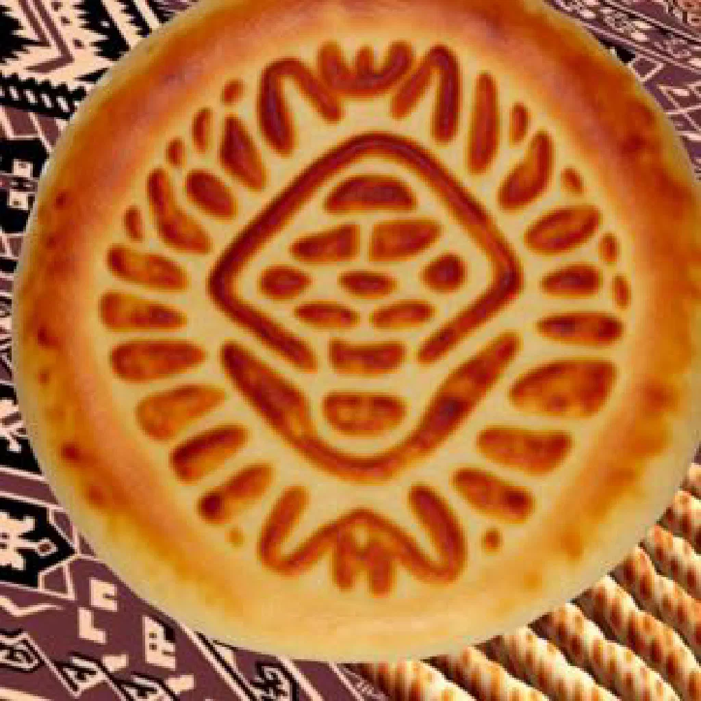 Round Tajik obi non flatbread with a golden crust and stamped centre