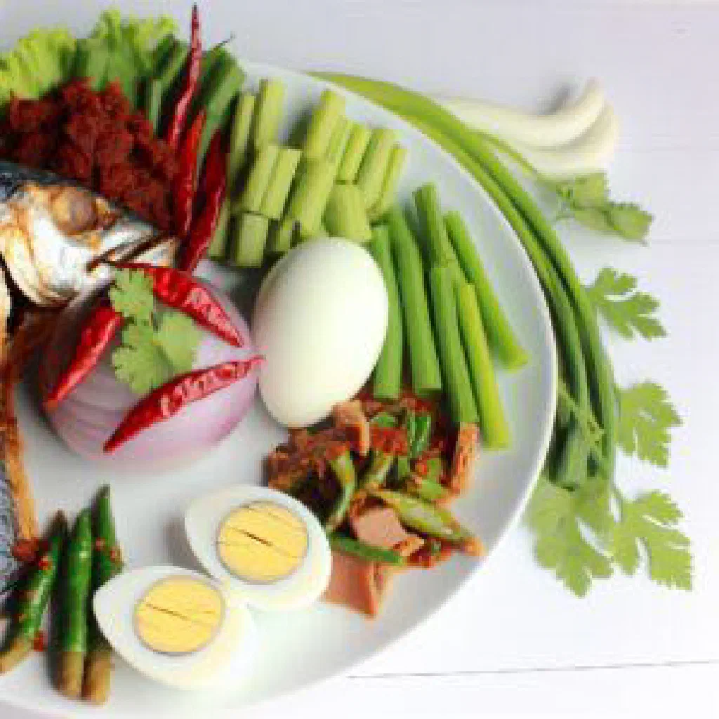 Bowl of spicy Nam Prik Long Rua chilli paste with fresh vegetables and rice