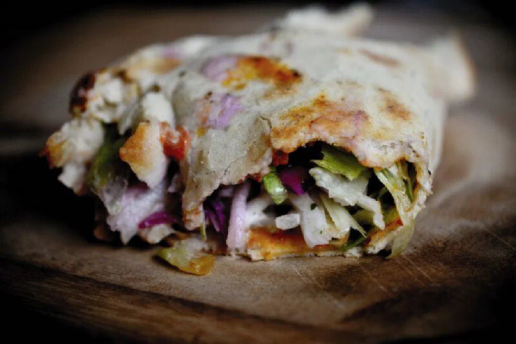 Thin crispy lahmacun flatbread topped with spiced minced meat and fresh herbs