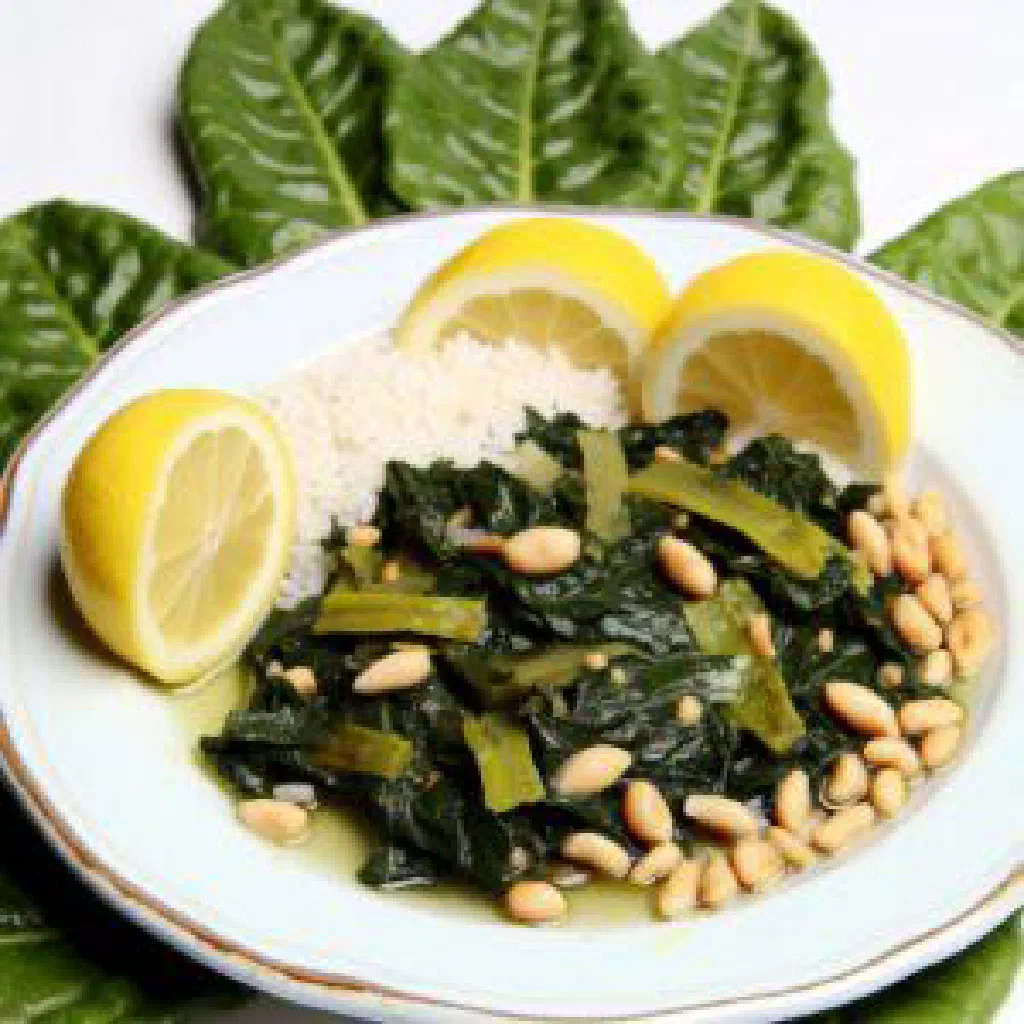 Braised Swiss chard in olive oil garnished with fresh herbs and lemon