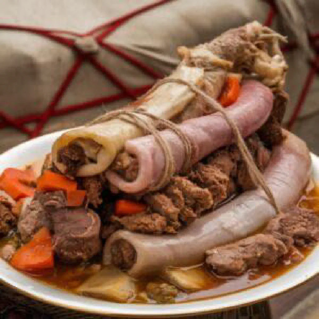 A hearty bowl of Turkmen chykyrtma stew garnished with fresh herbs