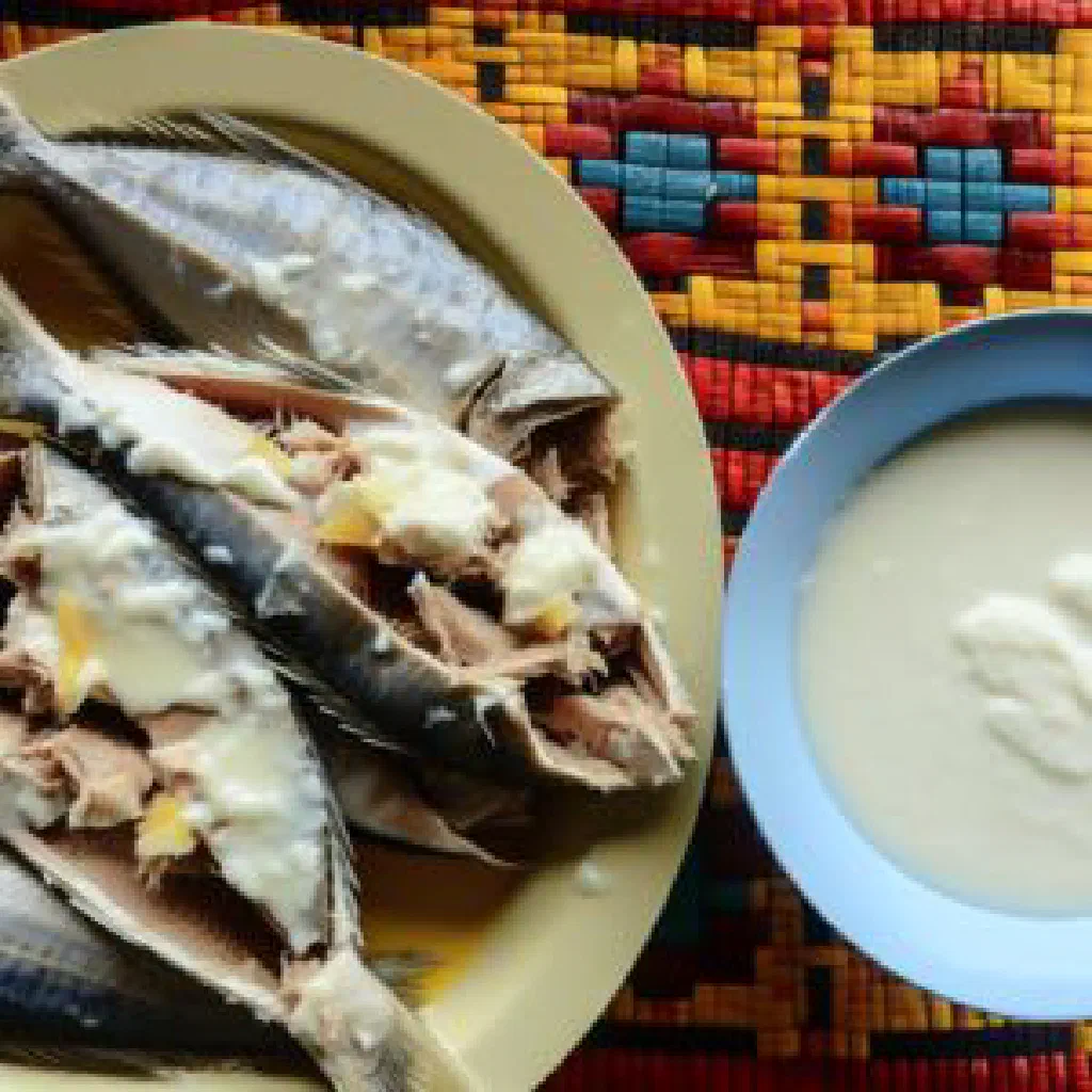 Boiled reef fish in creamy coconut sauce garnished with fresh herbs and lime