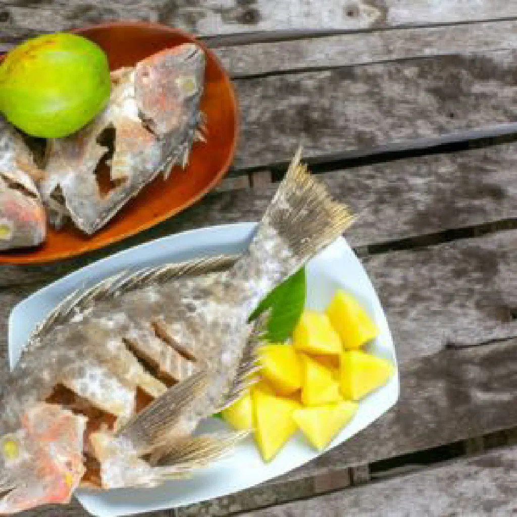 Golden crispy fried parrotfish served with fresh vegetables