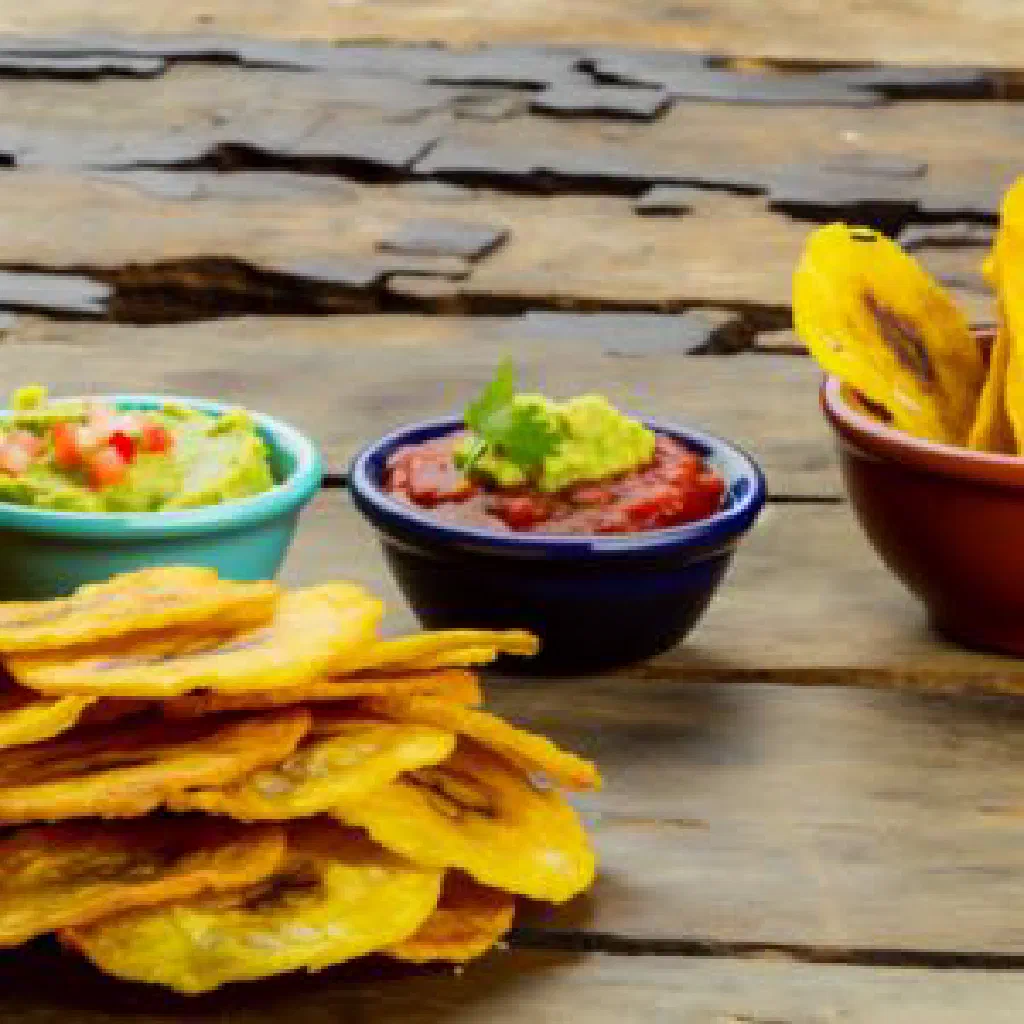 Golden fried patacones stacked on a plate with a dipping sauce
