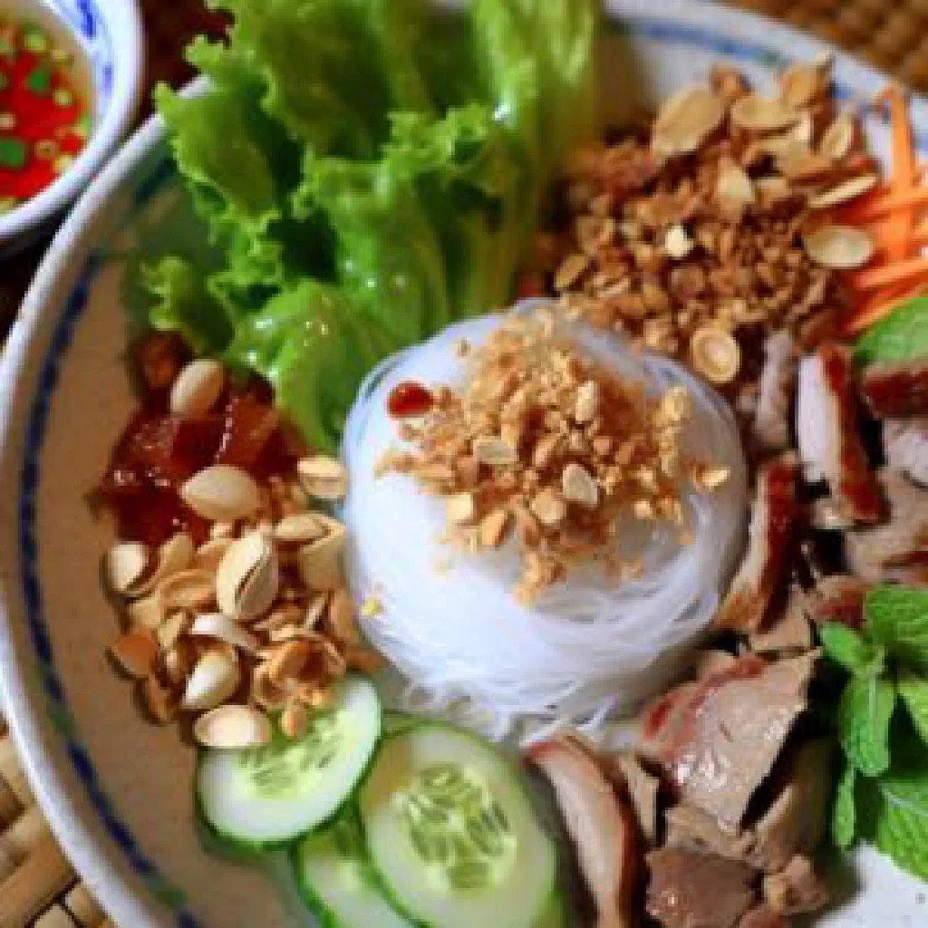 Bun thit nuong with grilled pork over rice noodles, fresh herbs and peanuts