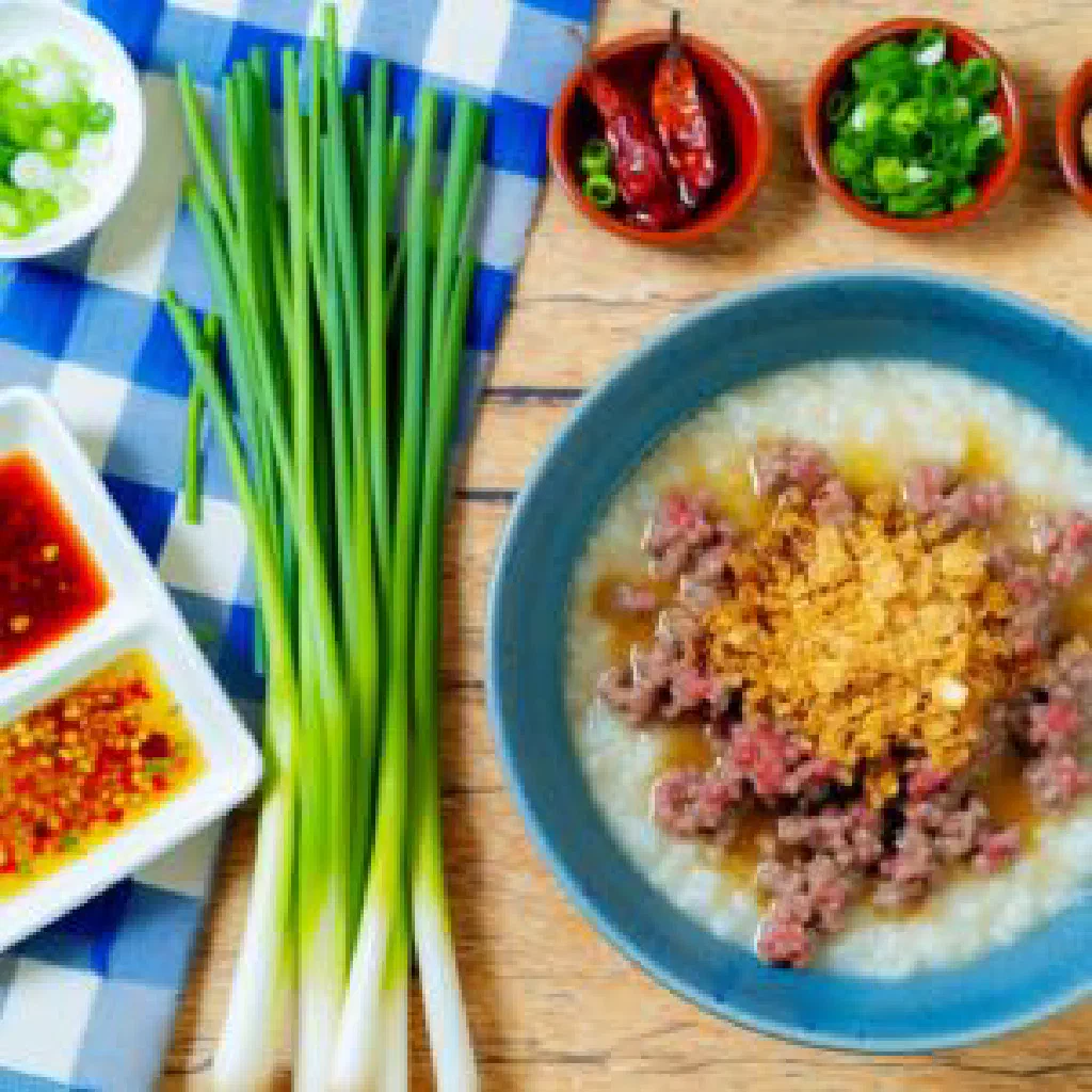 Bowl of Vietnamese chao bo beef rice soup garnished with spring onions and coriander