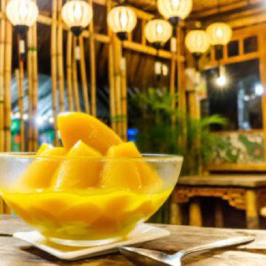 Che xoai mango dessert with coconut milk and tapioca pearls in a small glass